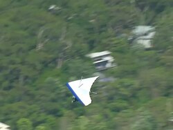 WS AERIAL ZI TS View of paragliding over seashore / Stanwell Park, Sydney New South Wales, Australia Stock Footage