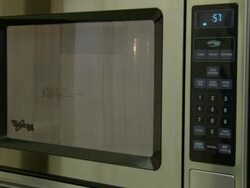 Hand pushes buttons on microwave machine in house at Pecan Street Inc. Stock Footage