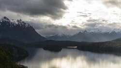 Rays of light moving over lake with mountains at sunset Stock Footage