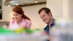 Man and woman fixing pie chat and laugh in the kitchen Stock Footage