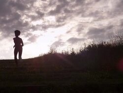 WS handheld silhouette female athlete running up hill  Stock Footage
