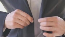 Man dressing upand buttoning jacket Stock Footage
