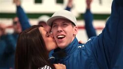 Woman kisses race-car driver's cheek, blue racing team celebrates victory Stock Footage
