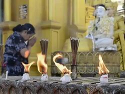 MS Shot of woman is praying in front of Buddha likeness and candles and incense burning in shwedagon pagoda / Yangon, Yangon Division, Myanmar Stock Footage