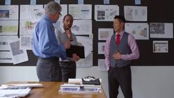 MS PAN Mature businessman presenting project on digital tablet to coworkers in office conference room Stock Footage