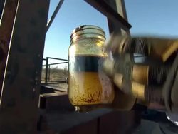 Oil pipe and crude oil at a Texas oilfield News Clip