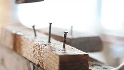 Hammer hitting a nail into wooden plank Stock Footage