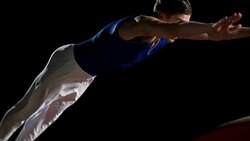 SLO MO DS Male gymnast performing front handspring on vault Stock Footage