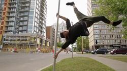 Young man doing parkour on pole in urban street Stock Footage