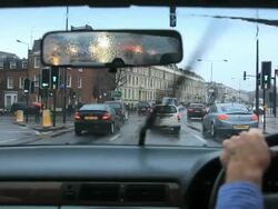 Driving in Kensington on a rainy wet day with busy traffic  in London Stock Footage