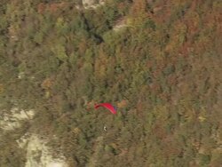 MS AERIAL TS Shot of paraglajder flying over wooded mountain area / Piedmont, France Stock Footage