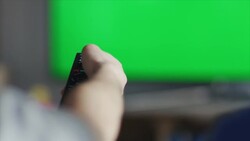 Guys sitting on couch watching tv and switching Stock Footage