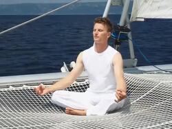 HD: Young Man Meditating On The Ocean Stock Footage