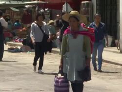 Busy street with stalls and traditionally dressed woman, Cochabamba, Bolivia Stock Footage