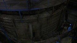 A railing surrounds a large, cement cylinder at a mining operation. Stock Footage