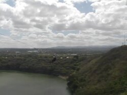 WS, PAN, Man riding zip line canopy tour above lagoon Stock Footage