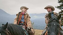 SLO MO Cowgirl and cowboy talking while riding horses Stock Footage