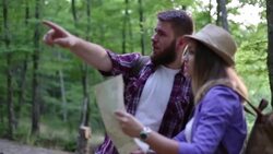 Young hipster couple backpacking lost in forest Stock Footage