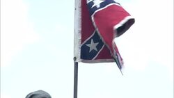 Confederate soldiers carry a Confederate flag as they ride away. Stock Footage