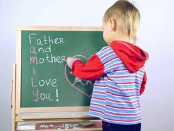 boy draws a card for parents on board Stock Footage