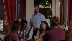 Restaurant owner stops by table to greet and chat with happy dinner party Stock Footage