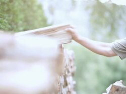  PAN Man selecting logs from wood pile / Stowe, Vermont, United States Stock Footage