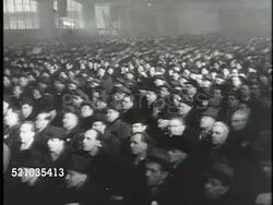 MOT 1948: CZECH COUP: VS Meeting hall filled w/ people, Communist Party Leader Klement Gottwald reading from paper on stage (No SOT), PAN Seated people in coats applauding, VS Unidentified leaders, audience raising right hand in vote. Instructional Video