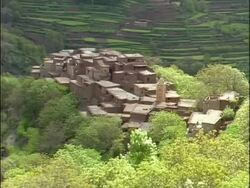 WA High angle view across Berber village nestled amongst terraced farmlands, Morocco, Africa Stock Footage
