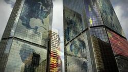 Global maps emblazon modern glass skyscrapers as clouds churn overhead. Stock Footage