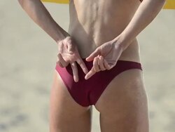 ECU CU of female beach volleyball player's hand on her buttocks signaling her partner. Stock Footage