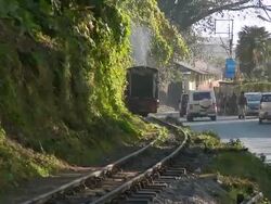 MS Toy train running along road / Kurseong, West Bengal, India Stock Footage