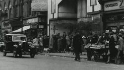 1939 MONTAGE Sellers marketing their wares on street carts in a city with cars passing by / United Kingdom Stock Footage