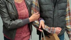New York couple with shopping bags walk arm-in-arm up sidewalk in Soho Stock Footage
