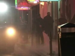 Medium Shot - Man spraying street clean with hose at night / New Orleans Louisiana Stock Footage