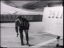 1966: UNITED AIRLINES MAINTENANCE: UA Flight engineer inspecting aircraft, crouched in front of landing gear. FLIGHT CREW: VS BEHIND Pilot & Co-pilot walking toward parked jet, unidentified male engineer in uniform walking up aircraft steps. Instructional Video