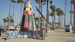 Graffiti covers the Public Art Walls, surrounded by palm trees, near the beach at the Pacific Ocean in Venice, California Stock Footage