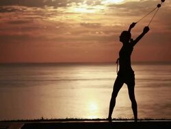 MS Sihouetted female poi dancer performs in front of fiery sunrise sky and ocean / Montezuma, Costa Rica Stock Footage