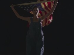 woman running towards camera with American flag Stock Footage
