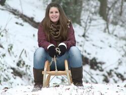 MS girl sitting on sled in winter / Saarburg, Rhineland-Palatinate, Germany Stock Footage