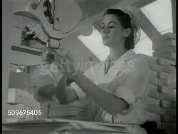 1943: SWEDEN: CHOCOLATE FACTORY: Woman assembling boxes on machine. CAFETERIA: Workers plating food in factory dining area. WS Employees eating in communal dining hall. LABOR LEADERS: WS Hotel. Men at conference table meeting, VS Union leaders. Instructional Video