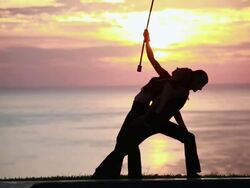 MS Couple poi dancers silhouette performing with firesticks in front of sunrise and ocean / Montezuma, Costa Rica Stock Footage