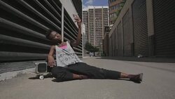 Cool young woman with boom box and skateboard taking selfie in sunny urban alley Stock Footage