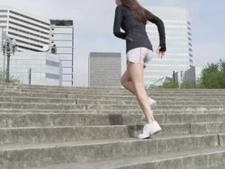 MS TU SLO MO Shot of young female jogger running up steps / Portland, Oregon, United States  Stock Footage