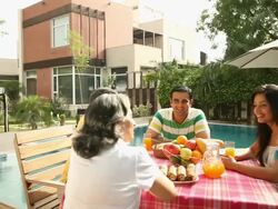 Family eating breakfast at poolside in a farm house  Stock Footage