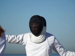 A man and woman fencing on the beach. - Slow Motion Stock Footage