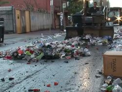 Medium Shot - Garbage truck pushes trash down a street into a large pile / New Orleans Louisiana Stock Footage