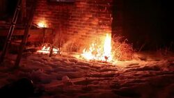 Firefighter sits in window of burning home and sprays flames, 3 clips Stock Footage
