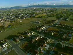 Low altitude aerial of newly built subdivision in Bozeman, MT with mountain range in BG Stock Footage