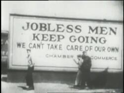 A photograph shows four men walking in front of a large sign which reads: Jobless Men Keep Going. News Clip