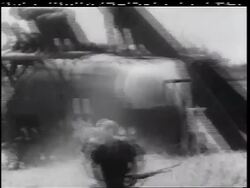 B/W 1960s soldier with gun running from crashed helicopter with more soldiers on top + jumping off Stock Footage